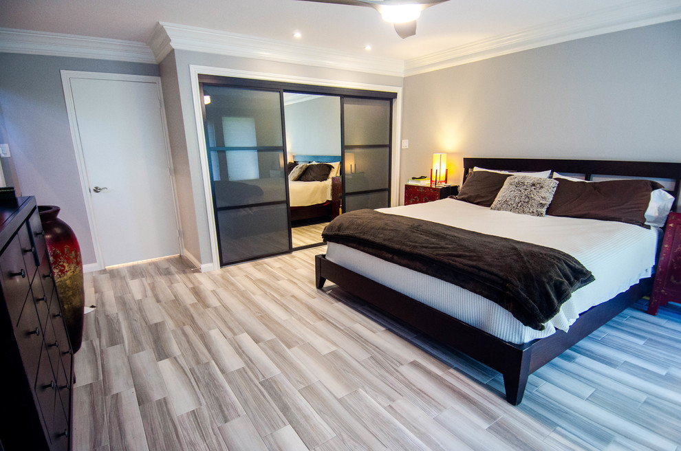 Photo of a mid-sized transitional master bedroom in Houston with grey walls, porcelain floors and grey floor.
