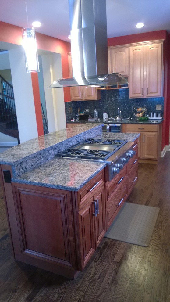 Example of a mid-sized transitional galley medium tone wood floor eat-in kitchen design in Chicago with a double-bowl sink, raised-panel cabinets, medium tone wood cabinets, granite countertops, beige backsplash, stainless steel appliances and an island