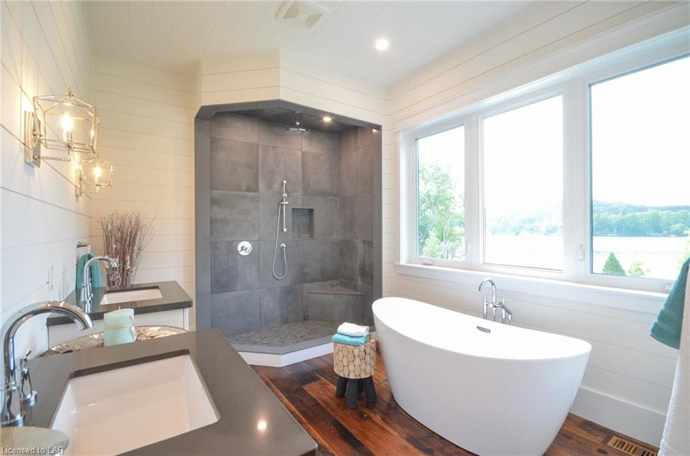 Inspiration for a large country master bathroom in Toronto with a freestanding tub, a corner shower, gray tile, cement tile, white walls, dark hardwood floors, an undermount sink, engineered quartz benchtops, brown floor, an open shower and grey benchtops.