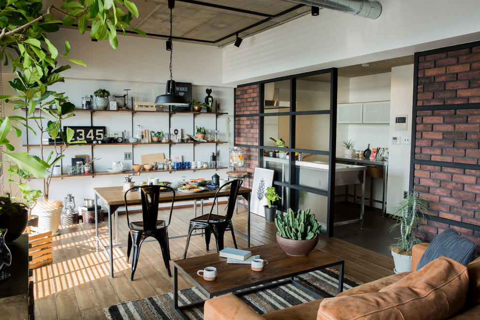 Inspiration for an industrial dining room in Other with white walls, medium hardwood floors and brown floor.