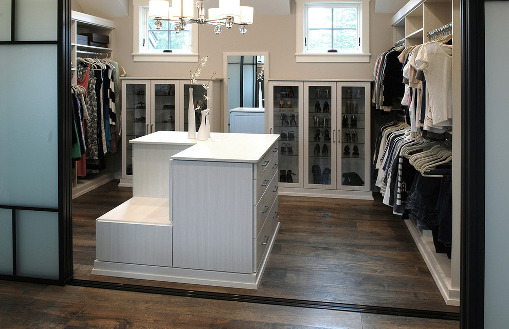 Design ideas for a large industrial women's walk-in wardrobe in Chicago with flat-panel cabinets, light wood cabinets, medium hardwood floors and brown floor.