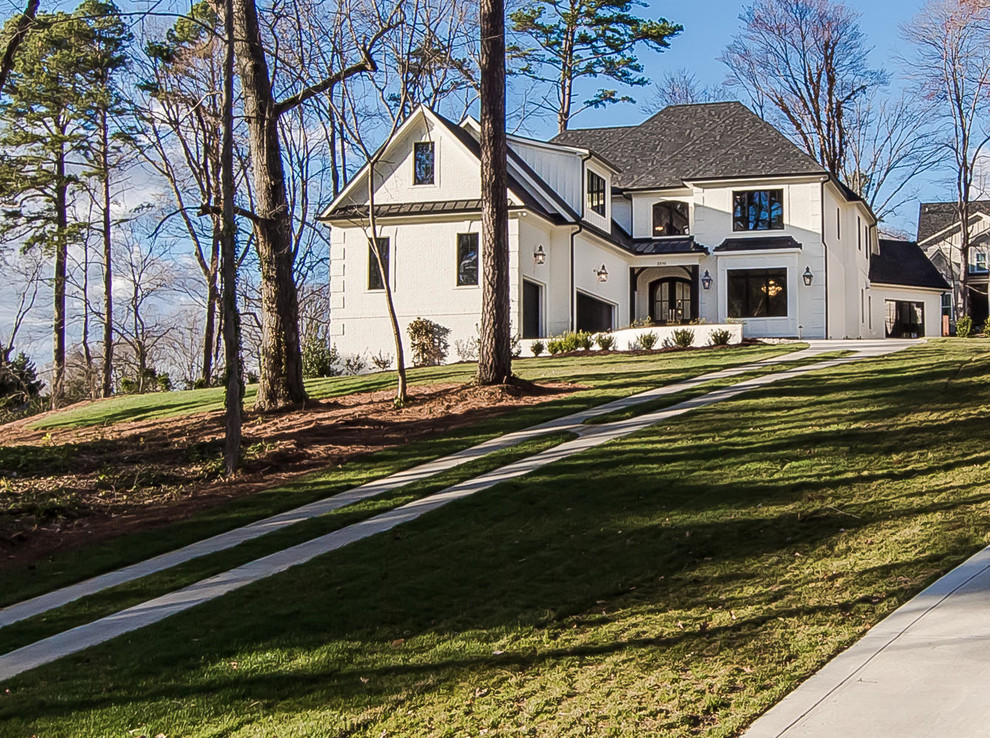 Inspiration for a mid-sized transitional white two-story stucco house exterior remodel in Raleigh with a clipped gable roof and a tile roof