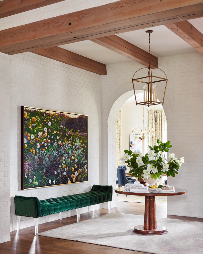 Inspiration for a large transitional foyer in Other with white walls, medium hardwood floors, a double front door, a light wood front door, brown floor, exposed beam and brick walls.
