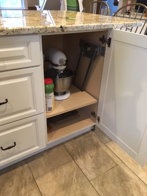 Eat-in kitchen - mid-sized transitional galley porcelain tile eat-in kitchen idea in Boston with an undermount sink, raised-panel cabinets, white cabinets, granite countertops, black appliances and an island