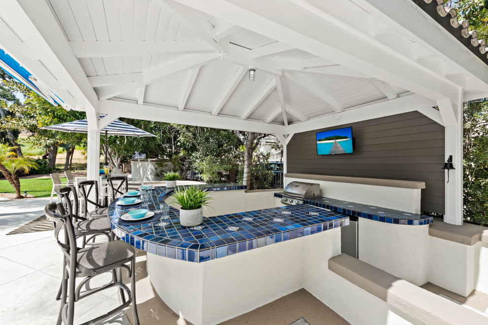 Design ideas for a transitional backyard patio in Orange County with concrete slab and a gazebo/cabana.