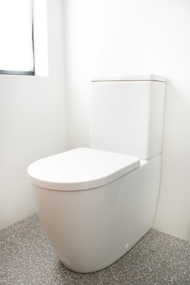 Inredning av ett modernt mellanstort grå grått en-suite badrum, med möbel-liknande, skåp i mellenmörkt trä, en dusch i en alkov, en toalettstol med hel cisternkåpa, vit kakel, mosaik, vita väggar, klinkergolv i porslin, ett fristående handfat, bänkskiva i kvarts, grått golv och dusch med gångjärnsdörr