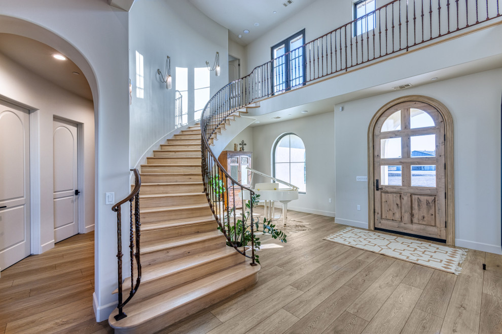 Two-Story Foyer with Curved Staircase and Arched Entry | Tuscan Farmhouse