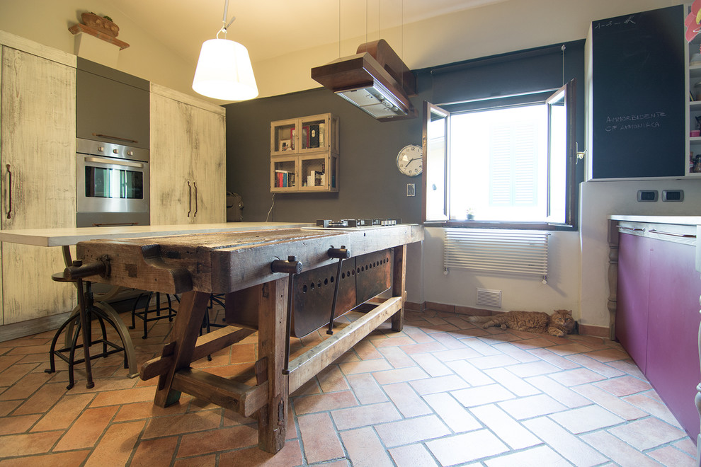 Inspiration for a small industrial galley open plan kitchen in Florence with an undermount sink, open cabinets, distressed cabinets, concrete benchtops, red splashback, stainless steel appliances, terra-cotta floors and with island.