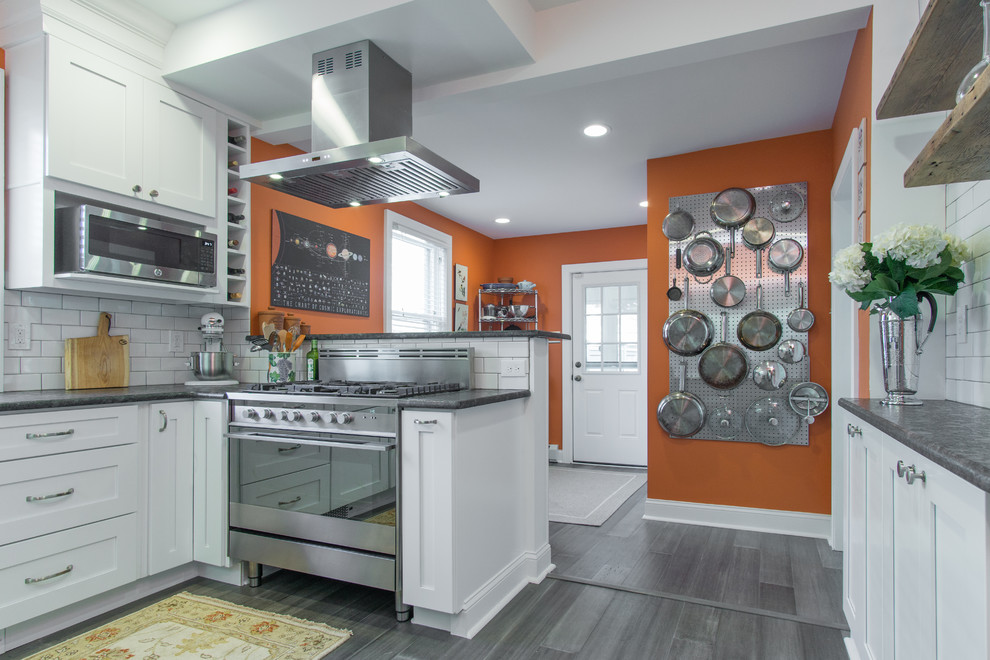 This is an example of a small modern u-shaped separate kitchen in Philadelphia with shaker cabinets, white cabinets, granite benchtops, white splashback, ceramic splashback, stainless steel appliances, vinyl floors, no island, grey floor, grey benchtop and a double-bowl sink.