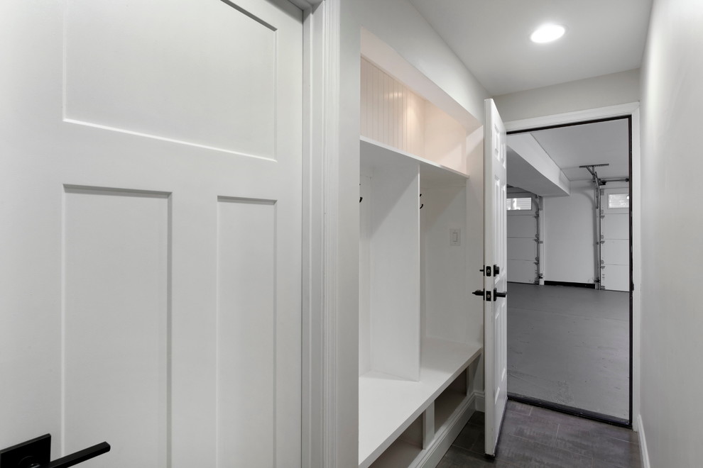 Photo of a large arts and crafts vestibule in DC Metro with grey walls, ceramic floors, a single front door, a white front door and grey floor.