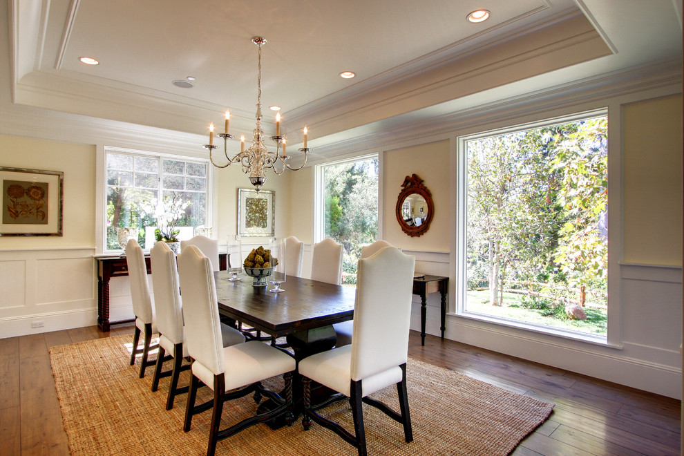This is an example of a traditional dining room in Los Angeles with beige walls and dark hardwood floors.