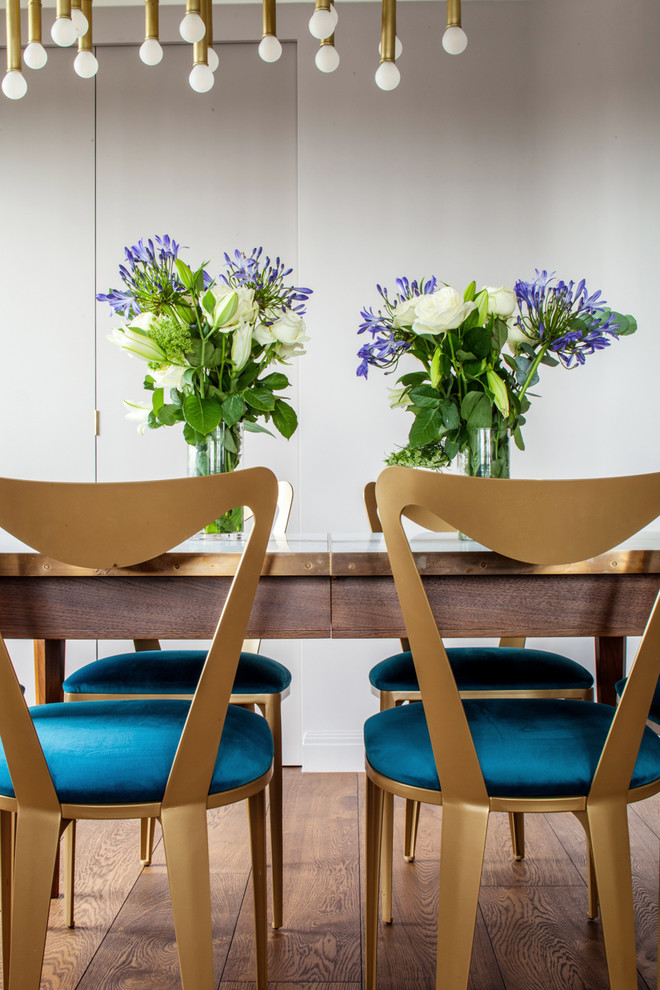 Contemporary open plan dining in London with beige walls, medium hardwood floors and brown floor.