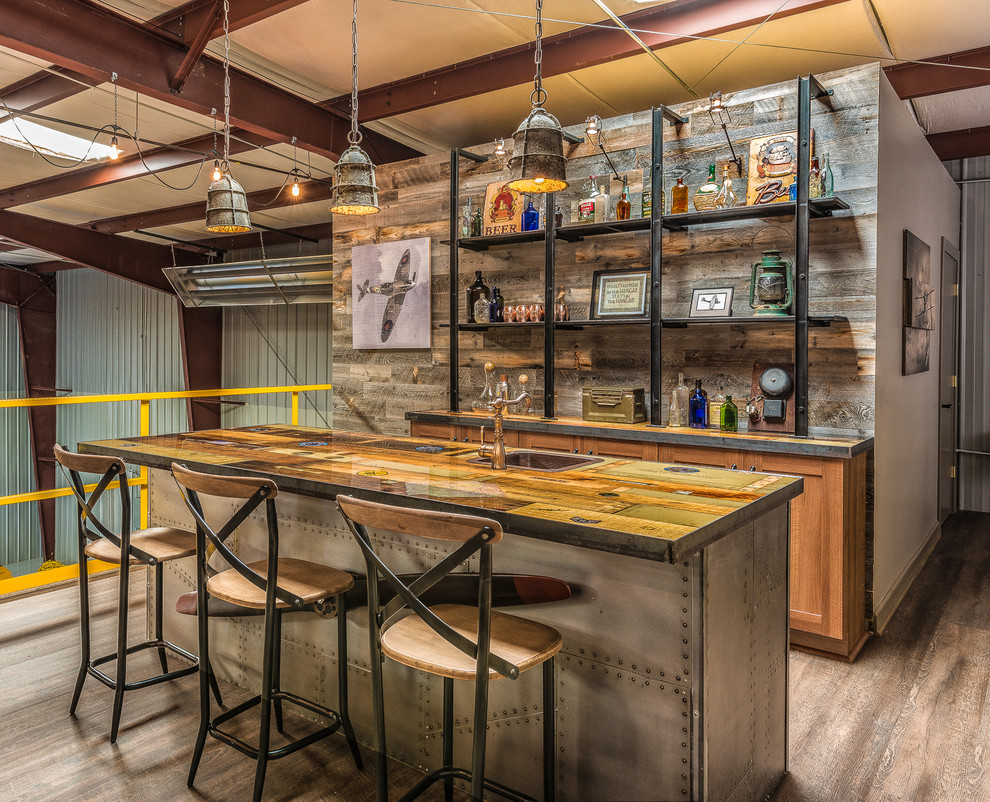 Industrial seated home bar in Charlotte with a drop-in sink, dark hardwood floors and shaker cabinets.