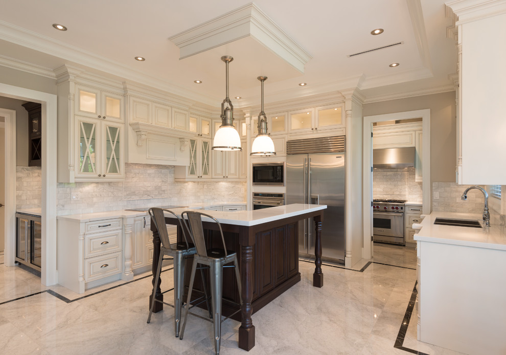 Inspiration for a traditional u-shaped kitchen in Vancouver with an undermount sink, raised-panel cabinets, white cabinets, quartz benchtops, white splashback, marble splashback, stainless steel appliances, marble floors, with island and white floor.