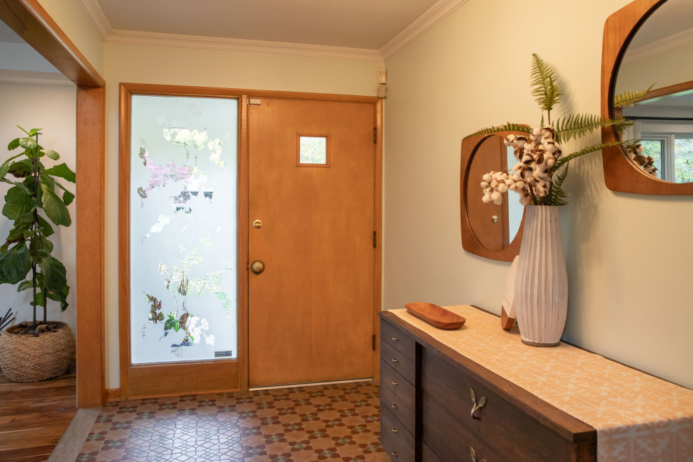 Inspiration for a mid-sized midcentury foyer in Indianapolis with white walls, medium hardwood floors, a single front door and a light wood front door.