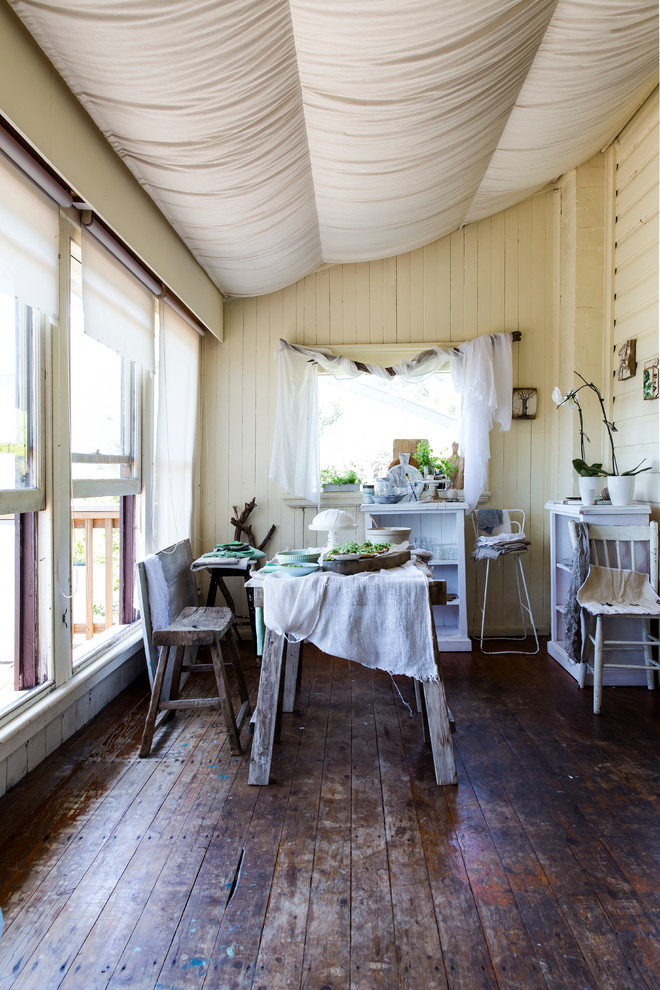 Inspiration for a traditional dining room in Sydney with yellow walls and dark hardwood floors.