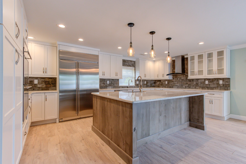 Enclosed kitchen - large transitional u-shaped porcelain tile and brown floor enclosed kitchen idea with an undermount sink, shaker cabinets, white cabinets, quartz countertops, brown backsplash, stainless steel appliances, an island and beige countertops