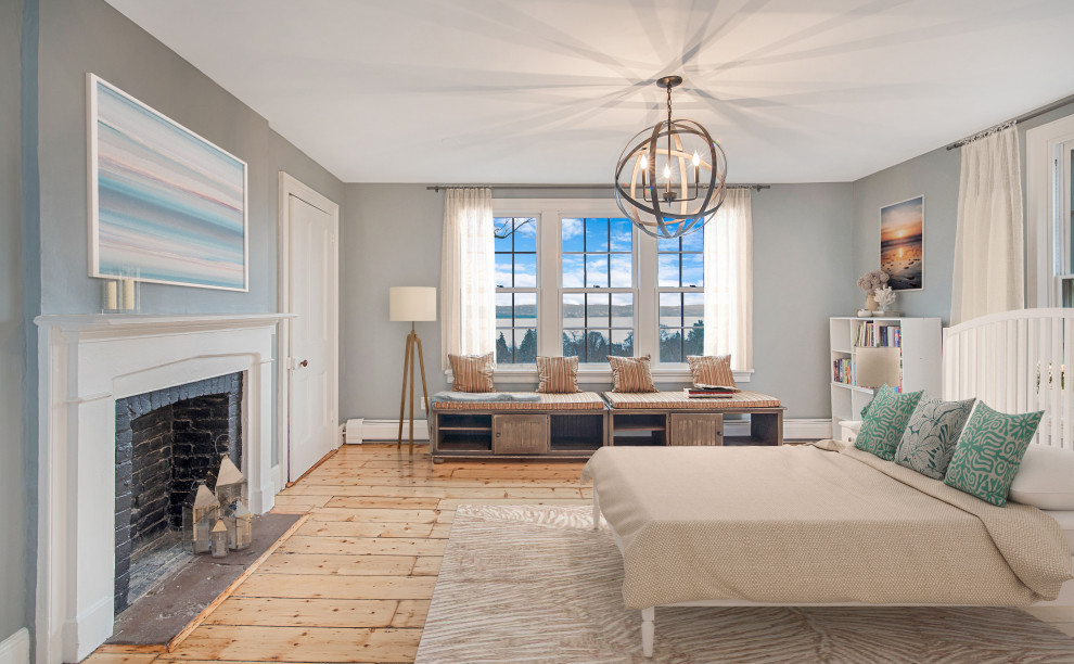 На фото: гостевая спальня среднего размера, (комната для гостей) в стиле неоклассика (современная классика) с серыми стенами, светлым паркетным полом, стандартным камином, фасадом камина из дерева и коричневым полом