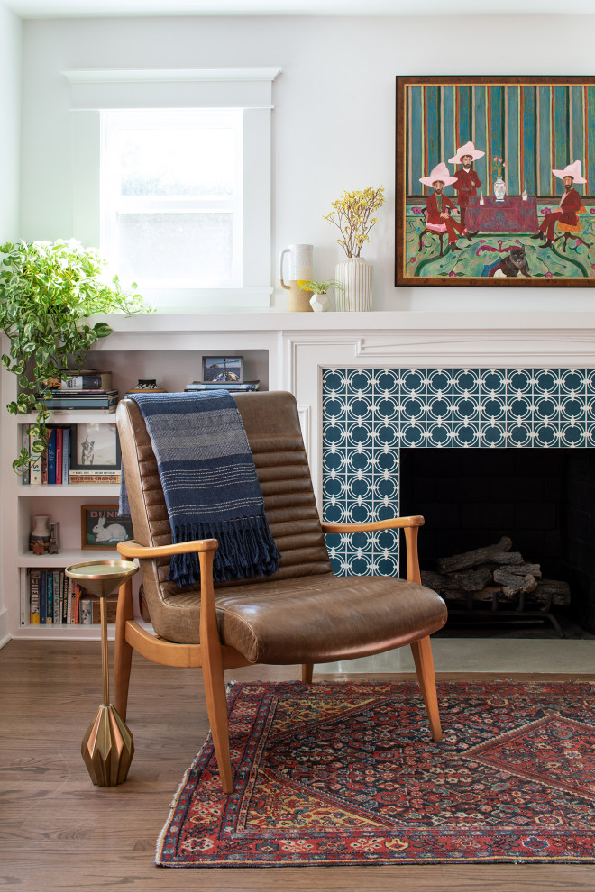 Foto de biblioteca en casa abierta de estilo americano de tamaño medio sin televisor con paredes blancas, suelo de madera en tonos medios, todas las chimeneas, marco de chimenea de baldosas y/o azulejos y suelo marrón