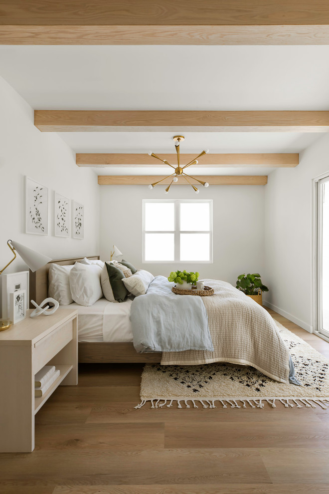 Imagen de dormitorio principal clásico renovado de tamaño medio con paredes blancas, suelo vinílico, suelo marrón y vigas vistas