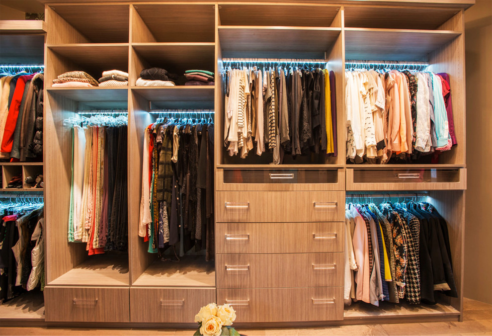 This is an example of a large transitional walk-in wardrobe in Los Angeles with flat-panel cabinets, light wood cabinets and ceramic floors.
