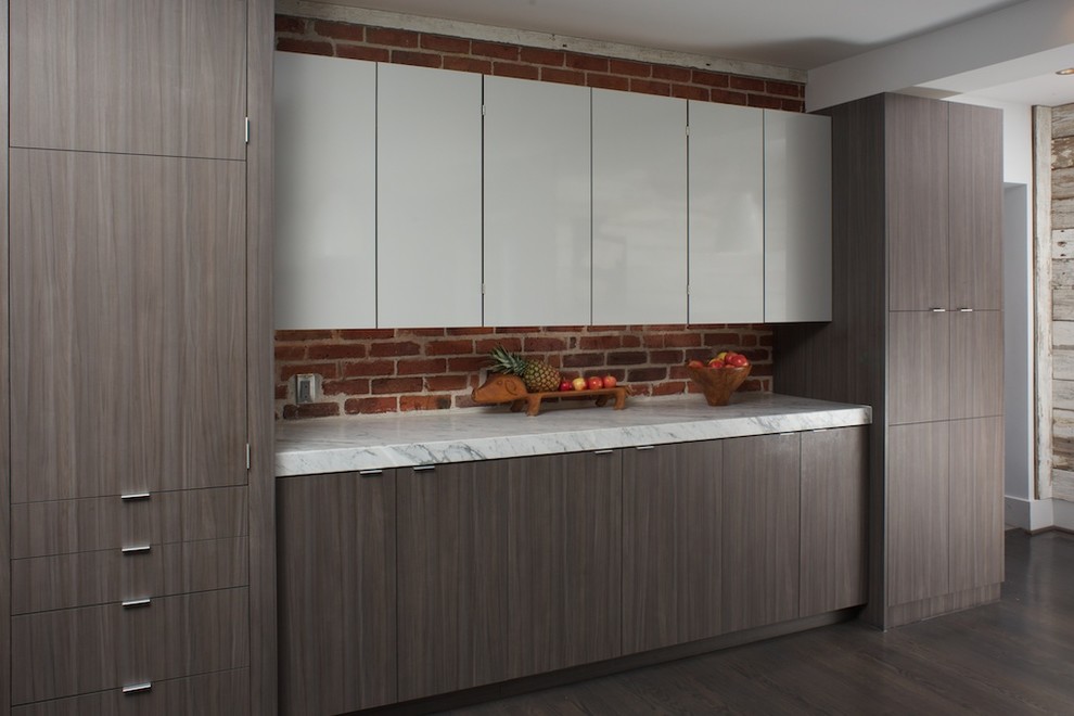 Transitional galley dark wood floor kitchen photo in Denver with flat-panel cabinets, brown cabinets, marble countertops, paneled appliances and an island