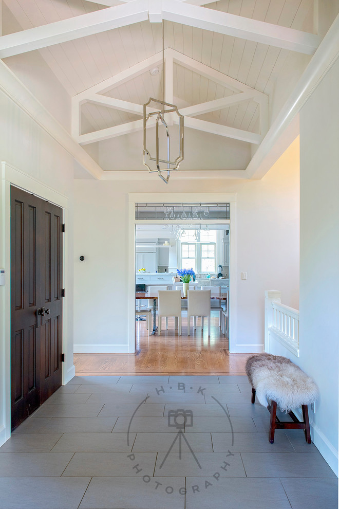 Example of a large porcelain tile and gray floor foyer design with white walls