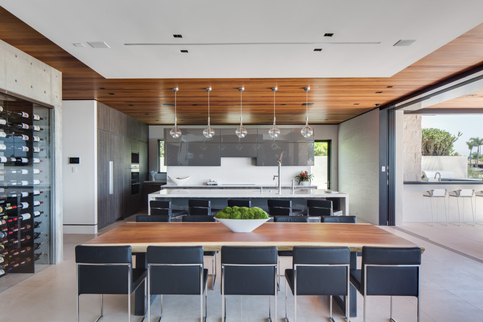 Photo of a contemporary eat-in kitchen in Orange County with flat-panel cabinets, grey cabinets, white splashback, with island, beige floor and white benchtop.