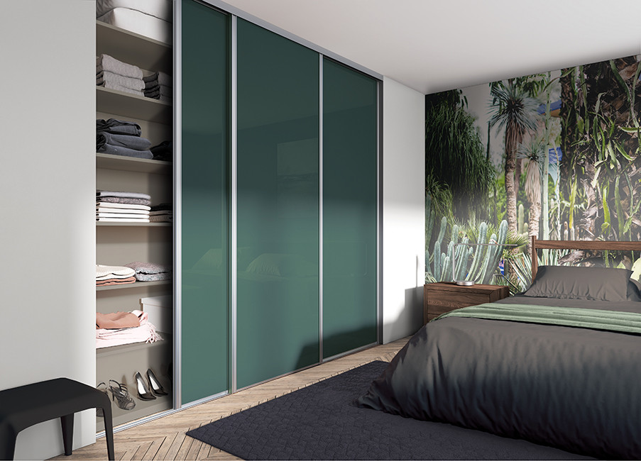 Design ideas for a modern walk-in wardrobe in Paris with louvered cabinets, green cabinets and painted wood floors.