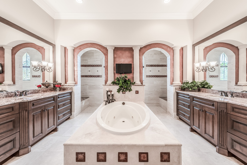 Design ideas for a mediterranean master bathroom in Jacksonville with raised-panel cabinets, dark wood cabinets, a drop-in tub, an open shower, multi-coloured walls, an undermount sink and an open shower.