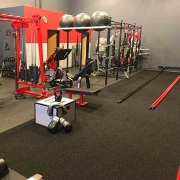 Design ideas for a large home weight room in Minneapolis with red walls and black floor.