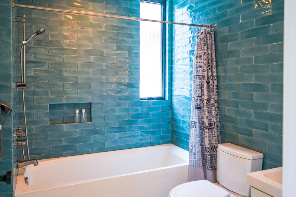 This is an example of a mid-sized modern 3/4 bathroom in Los Angeles with flat-panel cabinets, white cabinets, an alcove shower, a two-piece toilet, blue tile, ceramic tile, blue walls, a drop-in sink, engineered quartz benchtops, grey floor, a shower curtain, white benchtops, a niche, a single vanity, an alcove tub, ceramic floors and a built-in vanity.