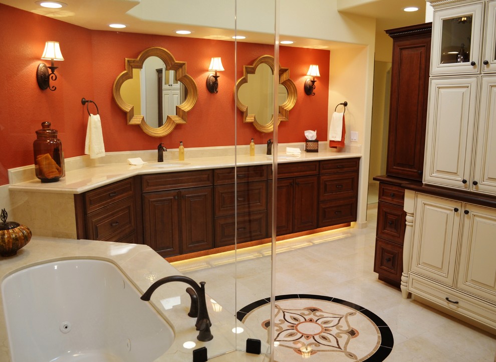 This is an example of a large traditional master bathroom in Phoenix with an undermount sink, raised-panel cabinets, dark wood cabinets, marble benchtops, an undermount tub, a double shower, a bidet, beige tile, stone tile, orange walls and porcelain floors.
