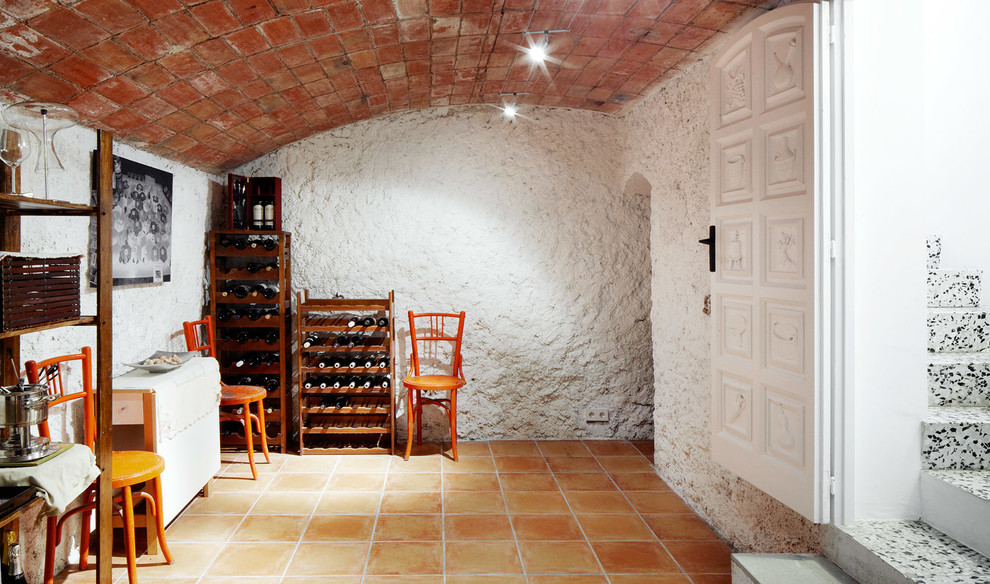 Photo of a country wine cellar in Other with terra-cotta floors.