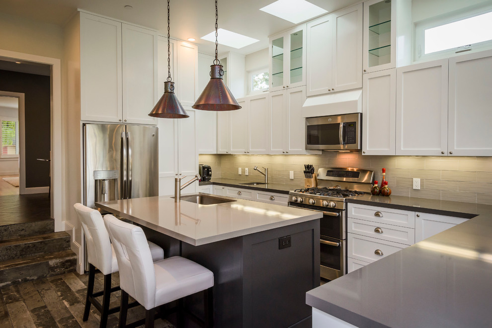 Large contemporary l-shaped open plan kitchen in San Francisco with an undermount sink, recessed-panel cabinets, white cabinets, wood benchtops, grey splashback, stainless steel appliances and with island.