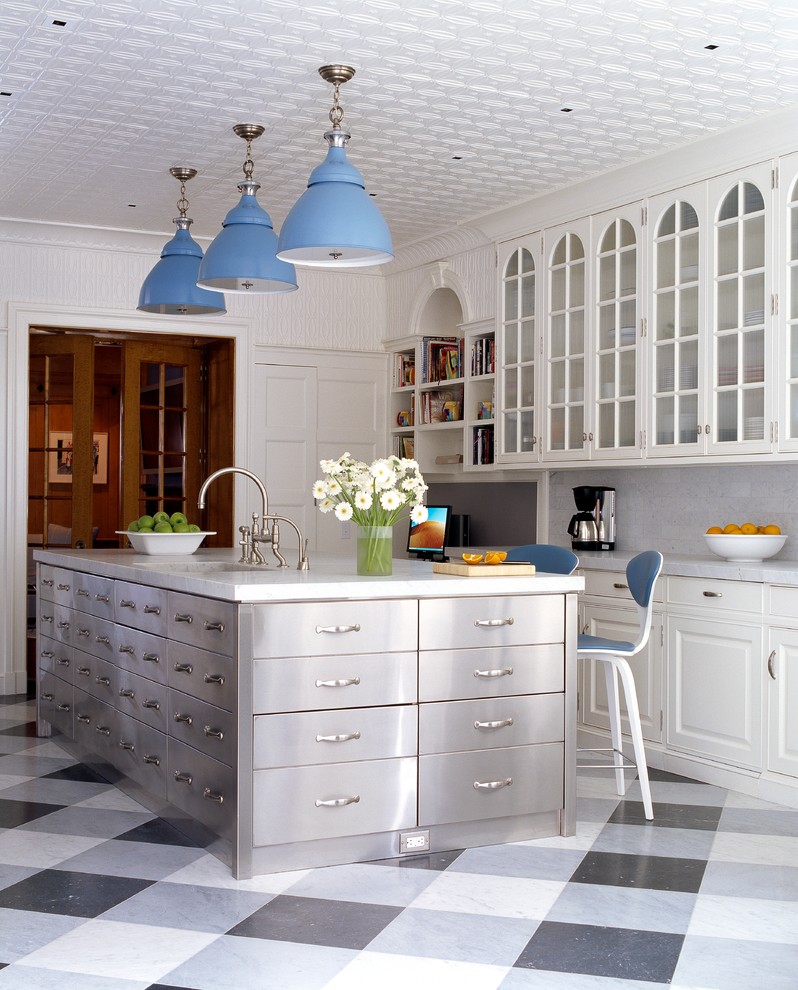 Example of a transitional kitchen design in New York with an undermount sink, raised-panel cabinets, white cabinets, white backsplash and an island