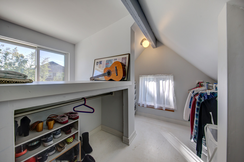 Photo of a mid-sized transitional gender-neutral walk-in wardrobe in Portland with open cabinets, grey cabinets, painted wood floors and grey floor.