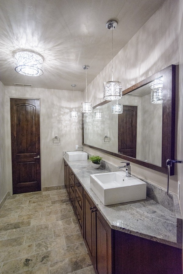 Inspiration for a mid-sized transitional 3/4 bathroom in Salt Lake City with raised-panel cabinets, dark wood cabinets, a drop-in tub, an open shower, a one-piece toilet, gray tile, white tile, marble, white walls, ceramic floors, a pedestal sink, soapstone benchtops, grey floor and an open shower.