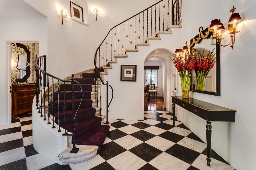 Expansive eclectic foyer in Los Angeles with white walls, marble floors, a single front door and a dark wood front door.