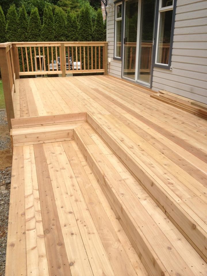 Example of a large backyard deck design in Vancouver with a pergola