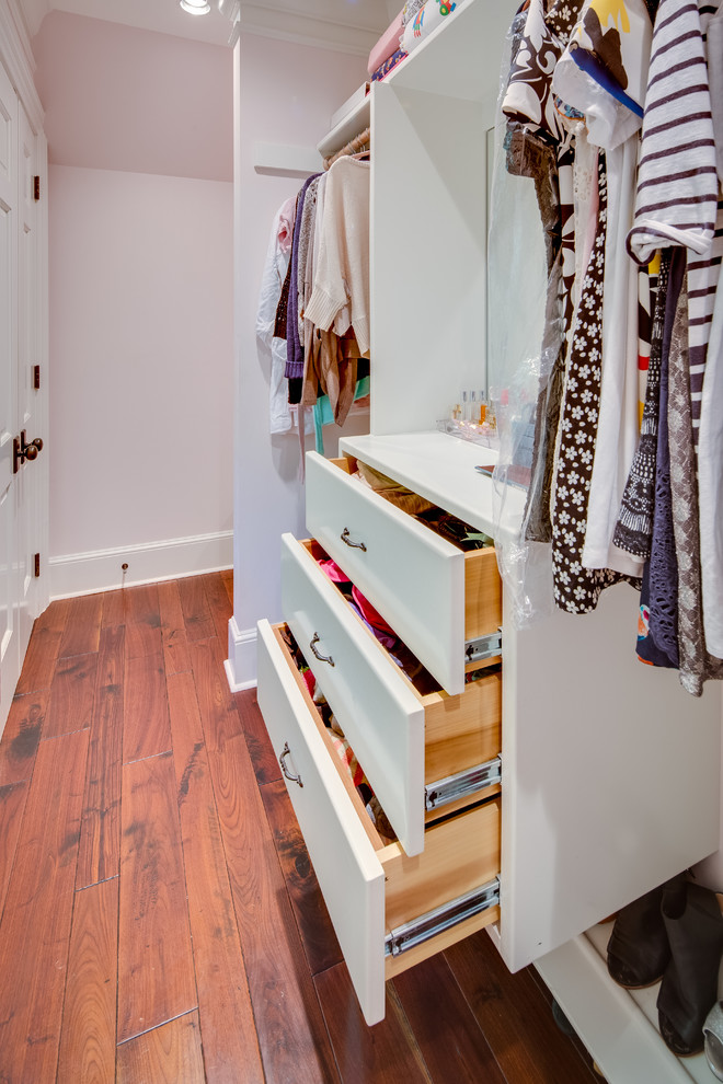 Photo of a mid-sized country women's walk-in wardrobe in DC Metro with flat-panel cabinets, white cabinets and medium hardwood floors.