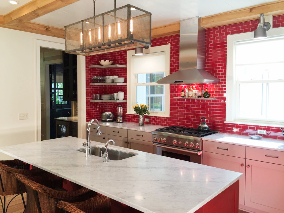This is an example of a mid-sized transitional single-wall open plan kitchen in Indianapolis with marble benchtops, red splashback, subway tile splashback, stainless steel appliances, medium hardwood floors, with island, shaker cabinets, an undermount sink and white cabinets.