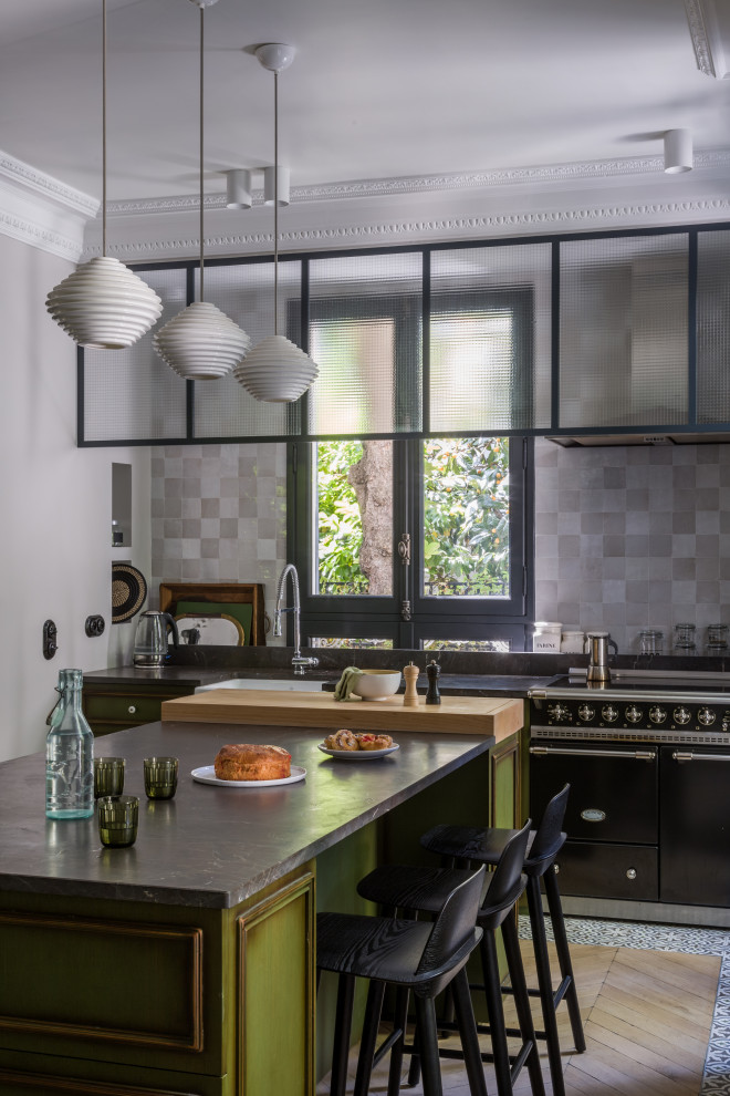 Inspiration for a mid-sized contemporary single-wall kitchen in Paris with an undermount sink, beaded inset cabinets, green cabinets, grey splashback, light hardwood floors, with island, beige floor and black benchtop.