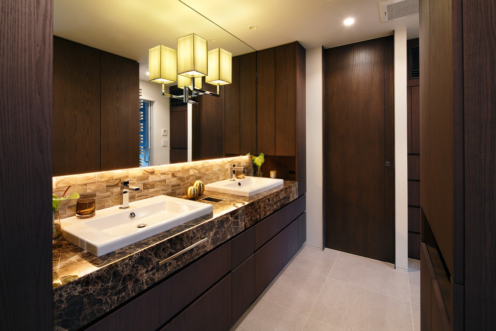 This is an example of a midcentury powder room in Tokyo with flat-panel cabinets, dark wood cabinets, white walls, a drop-in sink, marble benchtops and grey floor.