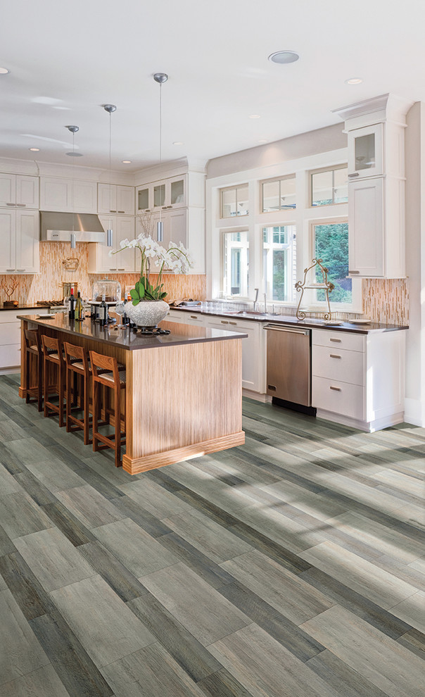 Example of a transitional u-shaped light wood floor and beige floor enclosed kitchen design in Orlando with an undermount sink, flat-panel cabinets, dark wood cabinets, granite countertops, white backsplash, subway tile backsplash, stainless steel appliances and an island