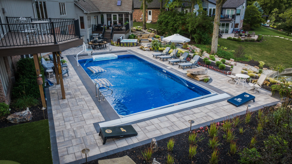 Example of a large mountain style backyard stone and rectangular pool landscaping design in Indianapolis