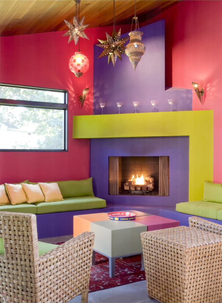 Photo of a small contemporary formal enclosed living room in Other with pink walls, carpet, a standard fireplace and a plaster fireplace surround.