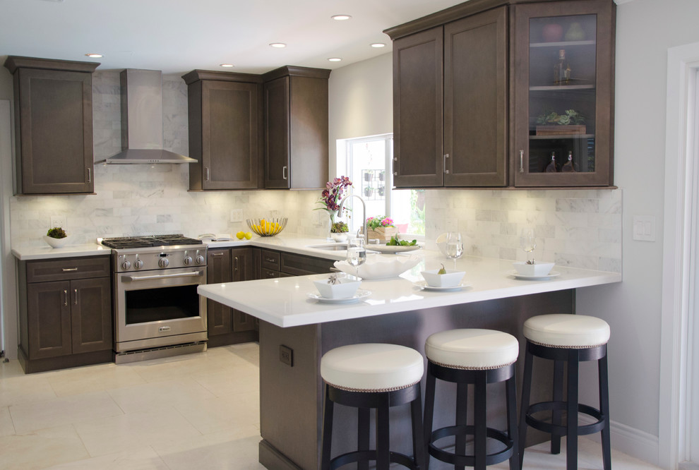 Inspiration for a mid-sized transitional u-shaped separate kitchen in Miami with an undermount sink, flat-panel cabinets, grey cabinets, quartz benchtops, white splashback, subway tile splashback and stainless steel appliances.