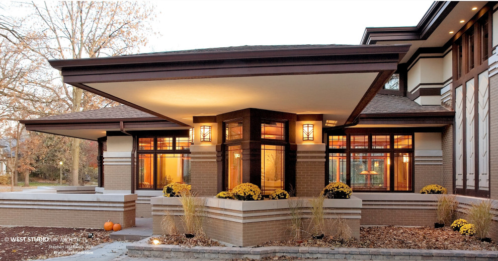 This is an example of a mid-sized asian brick brown house exterior in Chicago with a hip roof and a shingle roof.