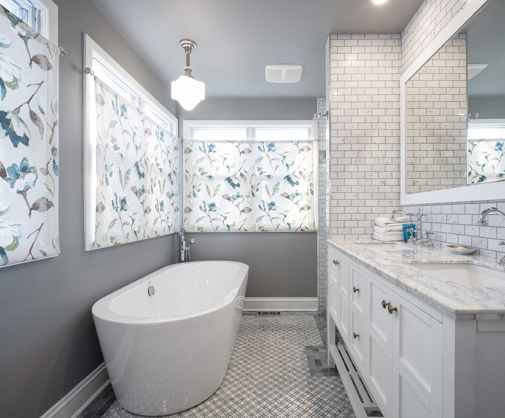 Design ideas for a mid-sized transitional master bathroom in Ottawa with recessed-panel cabinets, white cabinets, a freestanding tub, an alcove shower, a one-piece toilet, beige tile, ceramic tile, beige walls, ceramic floors, a console sink and marble benchtops.